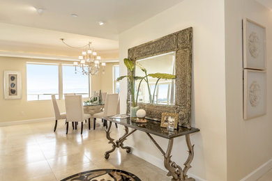 This is an example of a large contemporary foyer in Tampa with beige walls, travertine floors and beige floor.