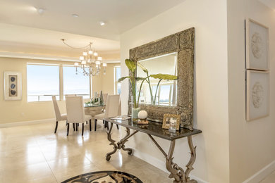 Large trendy travertine floor and beige floor foyer photo in Tampa with beige walls