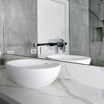 Modern white and grey bathroom with engineered terrazo counter and walls
