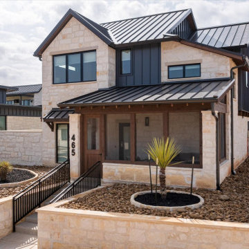 Striking modern ranch exterior with limestone façade, black metal roof, and a we