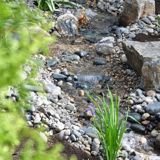 Photo of a large traditional backyard xeriscape in Calgary with river rock.