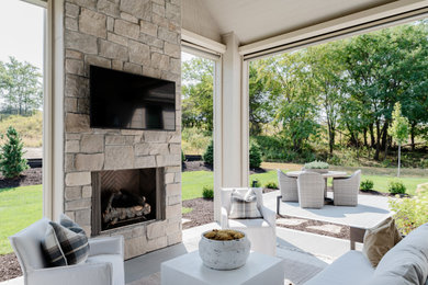 Mid-sized cottage chic backyard concrete patio photo in Omaha with a fireplace and a roof extension