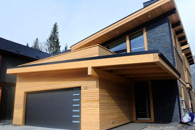 Example of a mid-sized minimalist brown two-story wood house exterior design in Calgary with a shed roof