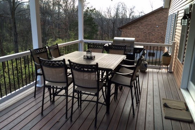 Photo of a mid-sized traditional backyard deck in St Louis with a roof extension.