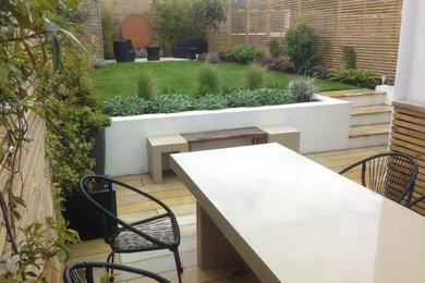 Inspiration for a medium sized contemporary back xeriscape full sun garden for summer in Sussex with natural stone paving and a wood fence.