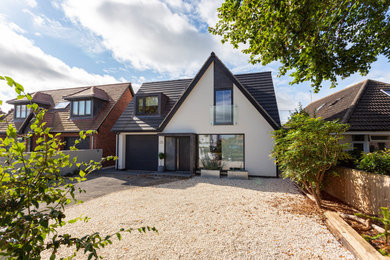 Contemporary two-storey white house exterior in Oxfordshire with a gable roof, a tile roof and a grey roof.