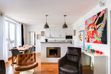 Photo of a mid-sized contemporary open concept family room in Paris with a home bar, white walls, light hardwood floors, a standard fireplace, a metal fireplace surround, a wall-mounted tv and brown floor.