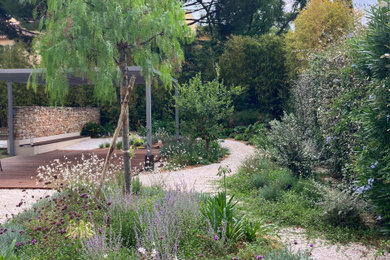 Aménagement d'un jardin arrière méditerranéen de taille moyenne et l'été avec pierres et graviers, une exposition ensoleillée et du gravier.