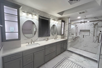 Aménagement d'une grande salle de bain principale classique avec un placard avec porte à panneau encastré, des portes de placard grises, une douche double, WC séparés, un carrelage blanc, des carreaux de porcelaine, un mur violet, un sol en carrelage de porcelaine, un lavabo encastré, un plan de toilette en quartz modifié, un sol blanc, un plan de toilette blanc, un banc de douche, meuble simple vasque, meuble-lavabo encastré et une cabine de douche à porte coulissante.