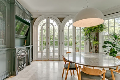 Mid-sized ornate marble floor and beige floor kitchen/dining room combo photo in Toronto with gray walls and a standard fireplace