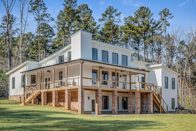 Large contemporary white split-level mixed siding house exterior idea in Raleigh with a shed roof