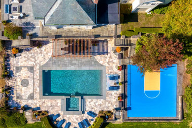 Foto de piscina alargada contemporánea grande rectangular en patio trasero con paisajismo de piscina y adoquines de piedra natural