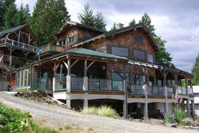 Example of a large mountain style brown three-story wood gable roof design in Seattle