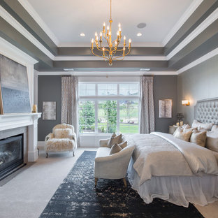 Großes Klassisches Hauptschlafzimmer mit grauer Wandfarbe, Teppichboden, Kamin, Kaminumrandung aus Holz und beigem Boden in Salt Lake City