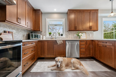 Kitchen - mid-sized transitional u-shaped vinyl floor and brown floor kitchen idea in Ottawa with an undermount sink, shaker cabinets, medium tone wood cabinets, quartz countertops, brown backsplash, marble backsplash, stainless steel appliances and brown countertops