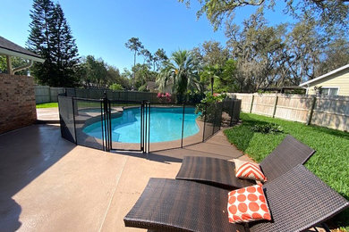 Pool house - large coastal backyard concrete and kidney-shaped natural pool house idea in Orlando