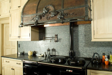 Tuscan kitchen photo in Milwaukee with blue backsplash, mosaic tile backsplash and black appliances
