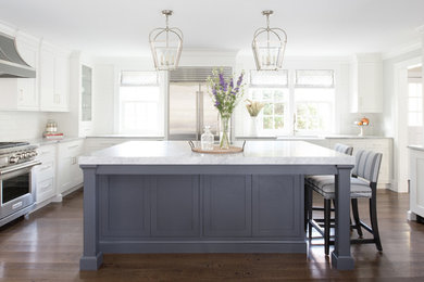 Mid-sized elegant l-shaped dark wood floor and brown floor enclosed kitchen photo in Newark with a farmhouse sink, shaker cabinets, white cabinets, white backsplash, subway tile backsplash, stainless steel appliances, an island and gray countertops