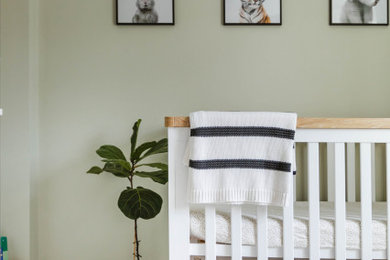 Medium sized scandi nursery for boys in Sussex with green walls, carpet and beige floors.