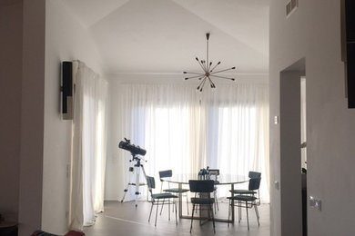 Esempio di una grande sala da pranzo aperta verso il soggiorno design con pareti bianche e pavimento grigio