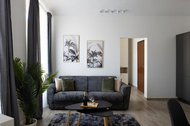 Esempio di un soggiorno moderno con pareti bianche, pavimento in gres porcellanato, nessun camino e pavimento beige