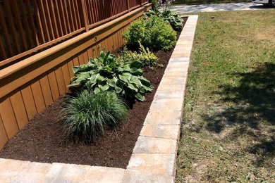 Photo of a small traditional front yard full sun garden for summer in New York with concrete pavers.
