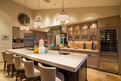 Inspiration for a transitional l-shaped beige floor and vaulted ceiling kitchen remodel in Minneapolis with an undermount sink, recessed-panel cabinets, light wood cabinets, beige backsplash, stainless steel appliances, an island and white countertops