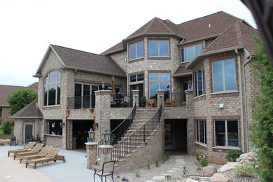 Patio kitchen - large traditional backyard concrete paver patio kitchen idea in Milwaukee with a roof extension
