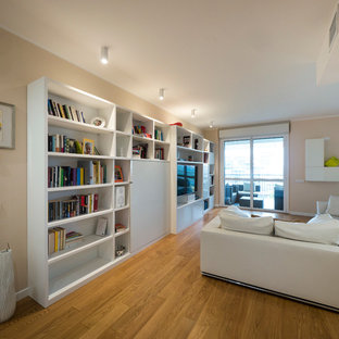 Foto på ett stort funkis allrum med öppen planlösning, med ett bibliotek, rosa väggar, ljust trägolv och en inbyggd mediavägg