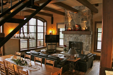 Living room - rustic open concept medium tone wood floor living room idea in Toronto with beige walls, a standard fireplace, a stone fireplace and a tv stand