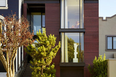 This is an example of a contemporary three-storey brown house exterior in San Francisco with wood siding and a flat roof.