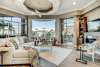 Mid-sized transitional open concept family room in Miami with beige walls, porcelain floors, a standard fireplace, a metal fireplace surround and a wall-mounted tv.