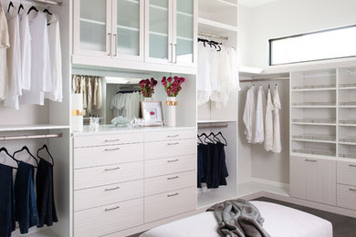 Inspiration for an expansive contemporary gender-neutral walk-in wardrobe in Philadelphia with white cabinets, dark hardwood floors, brown floor and flat-panel cabinets.