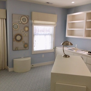 This is an example of a large modern home office and library in Philadelphia with a reading nook, blue walls, carpet, a two-sided fireplace, a stone fireplace surround, a freestanding desk and blue floors.
