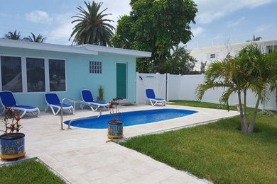 Example of a small classic backyard concrete paver and custom-shaped natural pool design in Miami