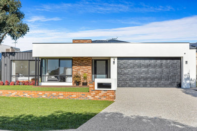 Photo of a large modern one-storey white house exterior in Perth with metal siding, a hip roof, a metal roof and a black roof.