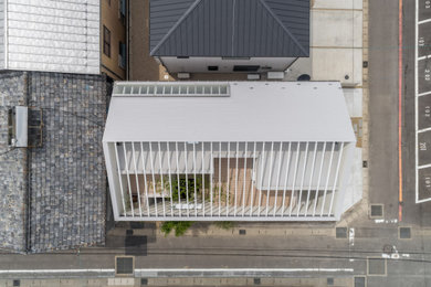 Diseño de fachada de casa beige y gris moderna de tamaño medio de dos plantas con tejado a dos aguas y tejado de metal