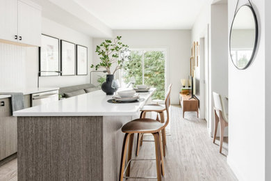 Kitchen - contemporary kitchen idea in Vancouver with flat-panel cabinets, quartz countertops, white backsplash, ceramic backsplash, stainless steel appliances and an island