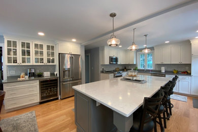 Inspiration for a mid-sized transitional eat-in kitchen remodel in Providence with flat-panel cabinets, quartz countertops and an island