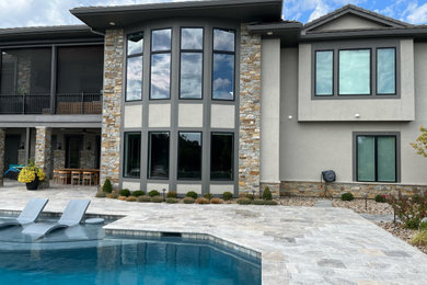 Inspiration for a large contemporary beige two-story stucco house exterior remodel in Kansas City