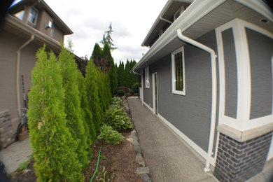 Diseño de fachada de casa gris y gris moderna de tamaño medio de dos plantas con tejado a dos aguas y tejado de teja de madera