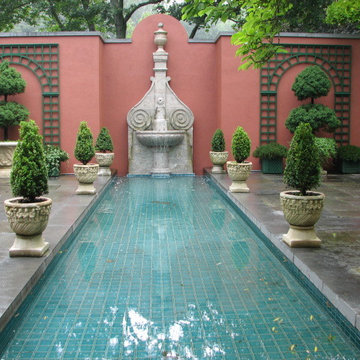 Topiary containers by the pool mirror the formal garden plantings