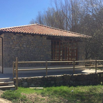 Vista de la fachada Oeste en la que se ve la acera perimetral sobre el muro.