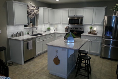 Eat-in kitchen - mid-sized transitional l-shaped ceramic tile and brown floor eat-in kitchen idea in Austin with a double-bowl sink, shaker cabinets, white cabinets, granite countertops, white backsplash, subway tile backsplash, stainless steel appliances and an island