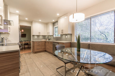 Example of a mid-sized trendy porcelain tile eat-in kitchen design in Vancouver with an undermount sink, flat-panel cabinets, quartz countertops, gray backsplash, glass tile backsplash, stainless steel appliances and no island
