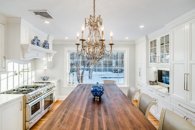 Enclosed kitchen - mid-sized traditional single-wall medium tone wood floor and brown floor enclosed kitchen idea in Bridgeport with an undermount sink, beaded inset cabinets, white cabinets, marble countertops, white backsplash, subway tile backsplash, stainless steel appliances, an island and white countertops