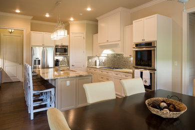 Example of a mid-sized classic l-shaped dark wood floor and brown floor open concept kitchen design in New Orleans with an undermount sink, recessed-panel cabinets, white cabinets, granite countertops, multicolored backsplash, mosaic tile backsplash, stainless steel appliances and an island