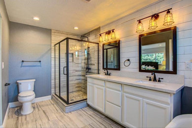 Inspiration for a large transitional master bathroom in Sacramento with recessed-panel cabinets, white cabinets, a freestanding tub, a corner shower, a one-piece toilet, beige tile, porcelain tile, grey walls, porcelain floors, an undermount sink, engineered quartz benchtops, beige floor and a hinged shower door.