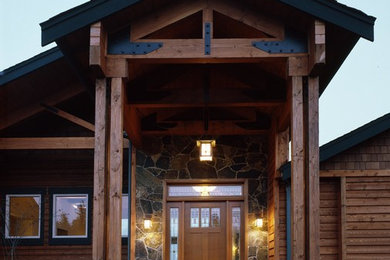 Large elegant light wood floor single front door photo in Seattle with brown walls and a medium wood front door