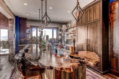Inspiration for a mid-sized country l-shaped eat-in kitchen in Denver with recessed-panel cabinets, dark wood cabinets, wood benchtops, multi-coloured splashback, mosaic tile splashback, panelled appliances, dark hardwood floors, with island, brown floor and brown benchtop.